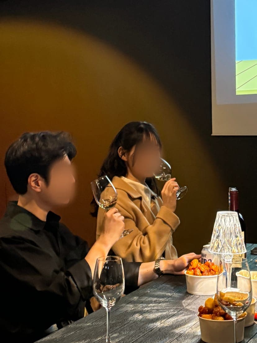 마주 앉아 와인을 나누는 참가자